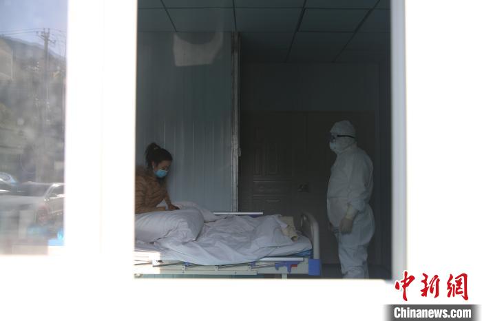 图为李斌在隔离病房向患者了解病情。　黄晓海 摄