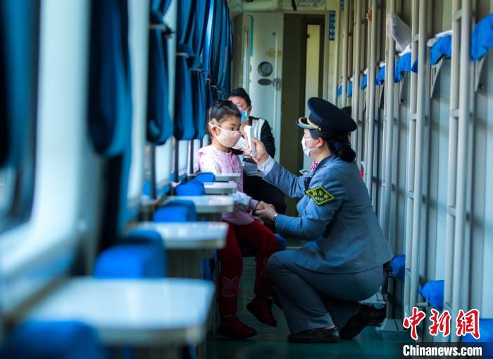 列车长杜晓琴在车厢内对重点旅客进行体温监测。　顾雪峰　摄